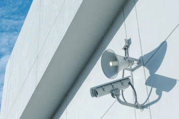 Loudspeakers and CCTV security cameras observation on a wall of a building