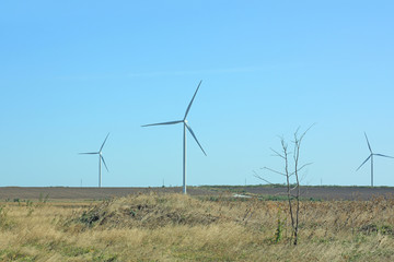 Wind turbines energy converters on the nature background.