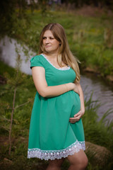 portrait of a pregnant young woman in dress in the garden