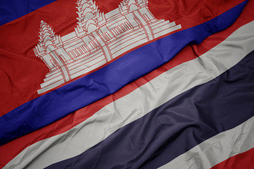 waving colorful flag of thailand and national flag of cambodia.