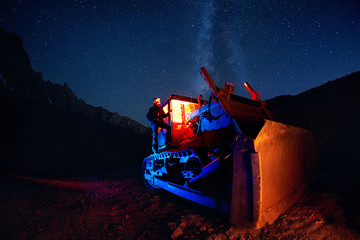 Man on bulldozer with night sky © pikoso.kz