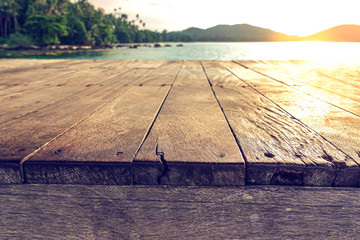 wood terrace over blue sea and tropical island beach background.