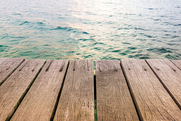 wood terrace over blue sea and tropical island beach background.