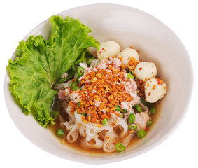 Thai street food Spicy Tomyum noodle soup with pork balls, Asian spicy seafood noodle soup. Close up of Thai Tom Yum spicy lime with pork, egg. Noodles Tom yum on white background