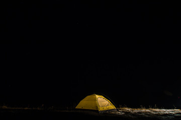 Camping for a starry night. The tent glows under a night sky full of stars. Milky way. leisure tourists. for friends. the first snow. the journey, autumn