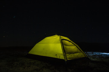 Camping for a starry night. The tent glows under a night sky full of stars. Milky way. leisure tourists. for friends. the first snow. the journey, autumn