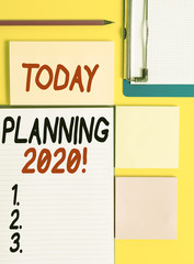 Conceptual hand writing showing Planning 2020. Concept meaning process of making plans for something next year Empty papers with copy space on yellow background table