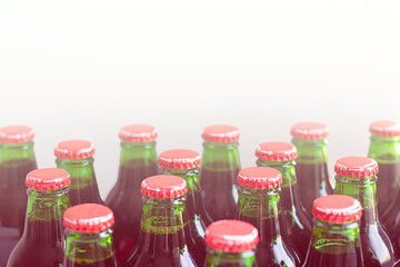 Green glass bottles without labels with dark liquid with metal easy twisting with arrow and word open on white background. Use without opener. Horizontal with copy space. Manufacture drinks, beverages