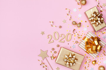 Golden gift or present boxes, 2020 numbers and Christmas decorations on pink background top view. Flat lay.