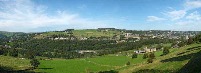 Fototapeta na wymiar a long panoramic view of the calder valley showing the village of luddenden and the town of sowerby bridge with surrounding woodland and meadows