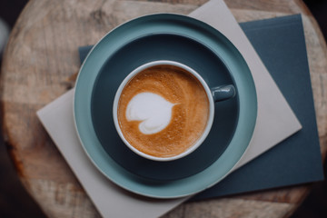 Cup of coffee and books on a wooden chair