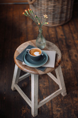 Cup of coffee,  books and flowers on a wooden chair