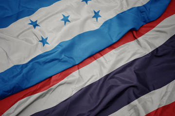 waving colorful flag of thailand and national flag of honduras.
