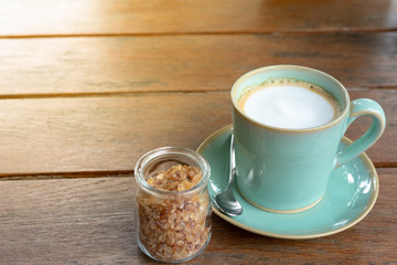 Hot coffee latte  and rock sugar brown on wood table.