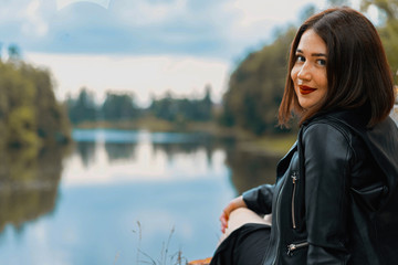 Young beautiful brunette woman in black dress posing at ancient ruins.