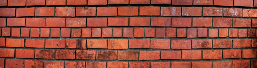 Obraz premium brick wall of red color, wide panorama of masonry