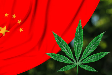 green leaf of hemp and the beautiful silk national flag of China, the concept of medical cannabis, legalization of drugs, drug trafficking crimes, close-up