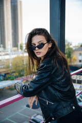 young girl in a leather jacket smokes cigarettes, rock style, cheeky and cute girl street posing style, rock punk lifestyle