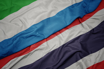 waving colorful flag of thailand and national flag of sierra leone