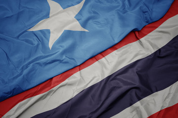 waving colorful flag of thailand and national flag of somalia.