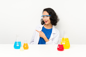 Young scientific asian girl pointing finger to the side