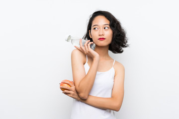 Asian young woman with an apple over isolated white background