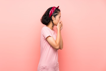 Obraz na płótnie Canvas Asian young woman over isolated pink background covering mouth and looking to the side
