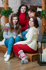 The company of beautiful women in the New Year's interior at home. Cute young women celebrate New Year or Christmas