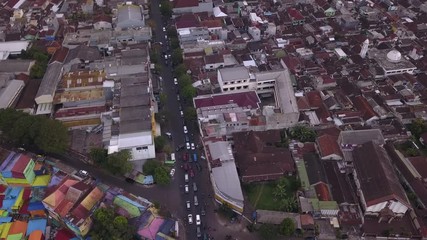 Aerial shot, view high above on the neighborhood and road traffic of Colorful Rainbow villlage at Malang city, Java island, Indonesia 