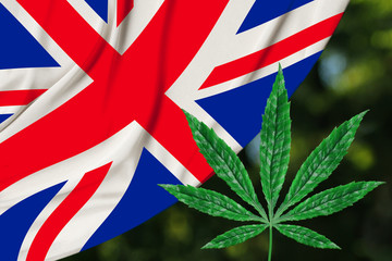 green leaf of hemp and the beautiful silk national flag of great britain, concept of medical cannabis, legalization of drugs, crime of drug dealers, close-up