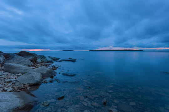 A cloudy day at the lakeside during blue hour with calm waters