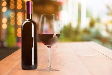 Red wine glass and buttle on wooden desk background