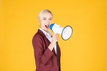 Business woman is announcing from megaphone on yellow background