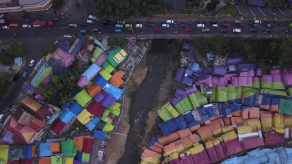 Aerial shot, view high above on the neighborhood and road traffic of Colorful Rainbow villlage at Malang city, Java island, Indonesia 
