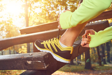 Preparing for jogging in autumn colored park.