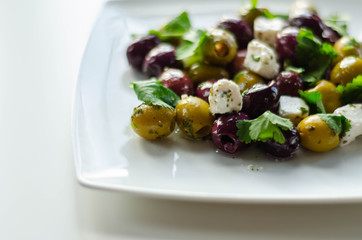 Fresh Greek salad based on green and black olives with pieces of white feta cheese and parsley