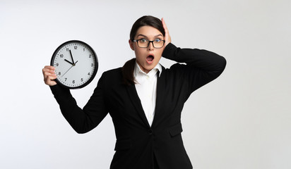 Shocked Businesswoman Holding Clock Clutching Head On White Background