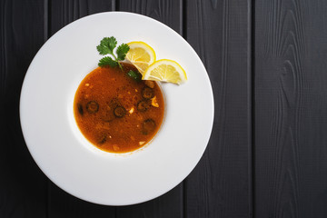 Homemade russian soup - solyanka. Dinner meal. Vegetable food with meat bouillon. Restaurant recipe menu on black background