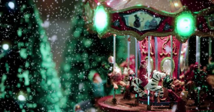 Christmas toy village scene ful of lights with a carousel toy, under the snow. Perfect decoration in store, for children at christmas holidays - close-up view - Christmas & event concept