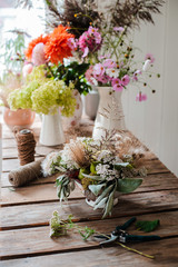 Female professional florist prepares the arrangement of wild flowers.