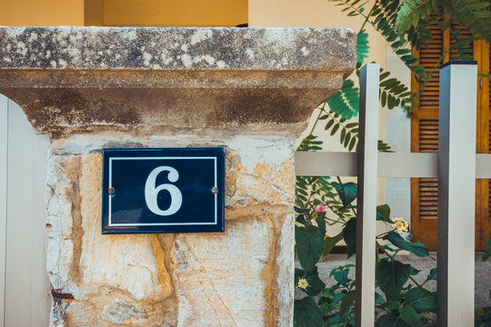 number 6 door sign on mediterranean facade