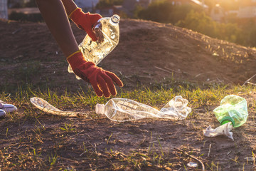 Garbage bottles picked up and thown into a trash bag. Plastic and food waste concept. Clean planet...