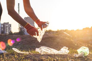 Garbage bottles picked up and thown into a trash bag. Plastic and food waste concept. Clean planet...