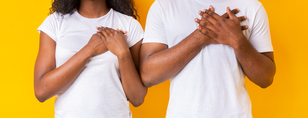 Cropped image of man and woman placing hands on their hearts