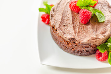 Gluten free tasty round cake based on Belgian chocolate decorated with fresh raspberries and mint