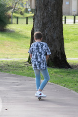 Young boy riding away on a scooter