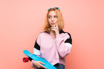 Naklejka premium Young skater woman over isolated pink background thinking an idea