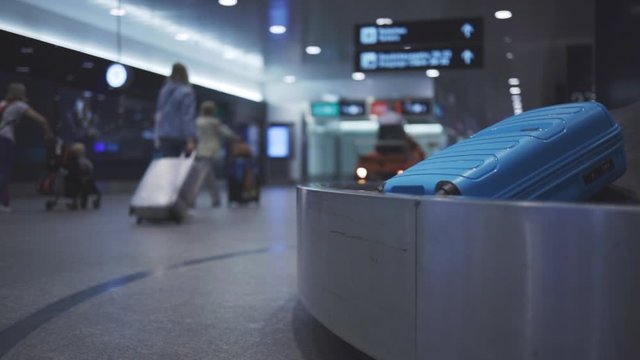 Baggage reclaim at the airport, travellers picking their luggages from the belt after arrival