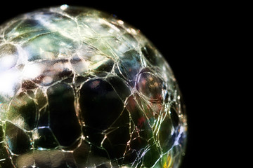 Glass sphere with a splintered surface and colored reflections