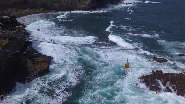 Aerial: Drone flying near suspension bridge , attraction on Timang beach, Java island, Indonesia